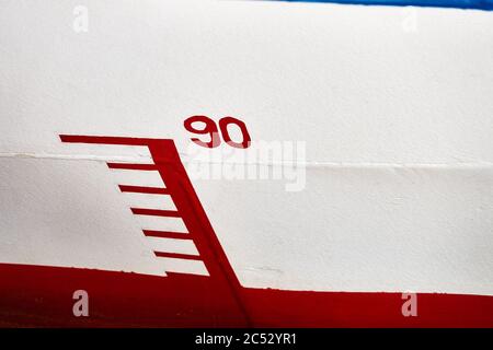 Markierung der Wassertiefe auf dem Rumpf eines Schiffes mit der Nummer '90', rot und weiß Stockfoto