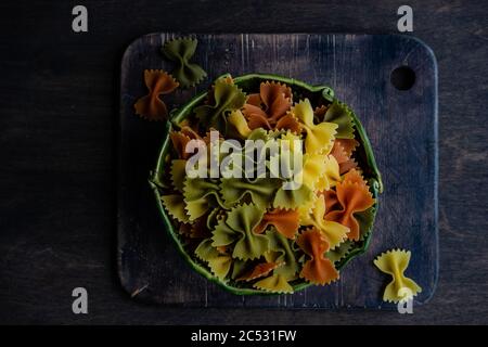 Schüssel getrocknete mehrfarbige Farfalle Pasta in einer Schüssel Stockfoto