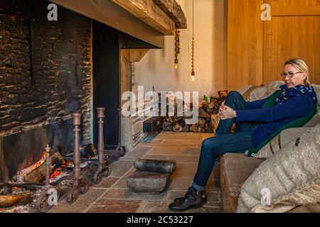 Vor einem riesigen offenen Kamin können Sie sich vor dem keltischen Bad und der Massage in der Ferme du Vent in der Nähe von Château Richeux, Saint-Malo, Frankreich, entspannen Stockfoto