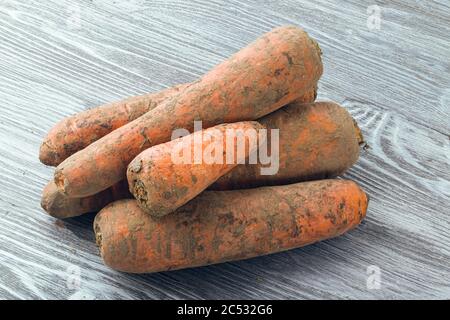 Große ungeschälte Karotten auf einem Holztisch. Stockfoto