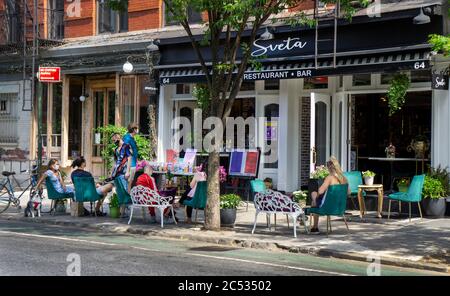 Menschen essen und trinken auf dem Bürgersteig vor dem Restaurant, New York City, New York, USA Stockfoto