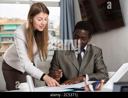 Freundliche Kollegen zusammen zu arbeiten und das Flirten am Arbeitsplatz in modernen Büro Stockfoto