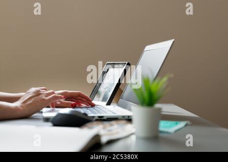 Junge Frauen, die von zu Hause aus arbeiten. Sitzen im Dachgeschoss mit Laptop in der Nähe von Dachfenster. Neues normales Konzept Stockfoto
