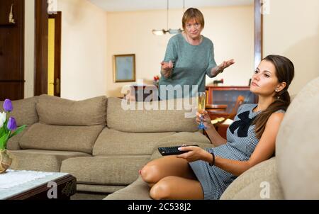 Ältere Frau, die zu Hause ihre traurige Erwachsene Tochter vorhält Stockfoto