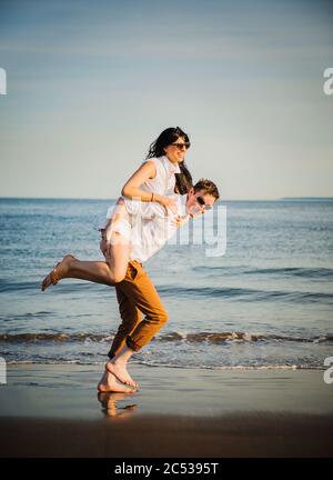 Junge Paare, die Spaß am Strand Stockfoto