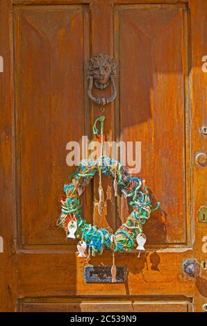 Kranz aus alter Angelschnur und Seil an einer Holztür in Appledore, Devon. Stockfoto