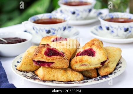 Nachmittagstee im Garten mit Scones, Erdbeermarmelade, Fingerbrote mit Gurke und Eiersalat. Stockfoto