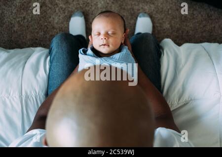 Neugeborenes Baby schläft in väterlichen Armen Stockfoto