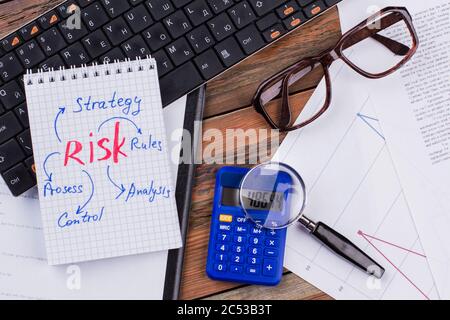 Flache Lay-Komposition mit Papieren, Lupe auf blauem Rechner, Tastatur auf Holzhintergrund. Stockfoto