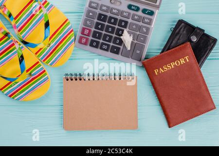 Kreatives Flat Lay Reisekonzept mit Reisepass, Flip-Flops und Rechner. Stockfoto