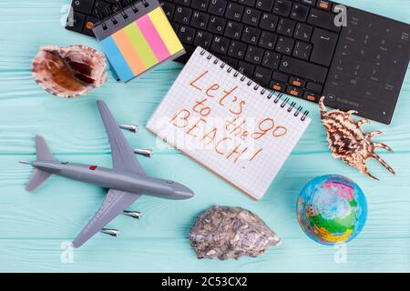 Spielzeug Flugzeug mit Globus, Muscheln und Tastatur auf blauem Hintergrund. Stockfoto
