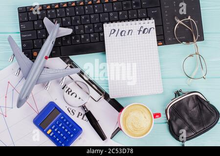 2018 Pläne auf Notebook mit Reisenden Accessoires Brille Brieftasche und Flugzeug auf Holztischplatte Hintergrund. Stockfoto