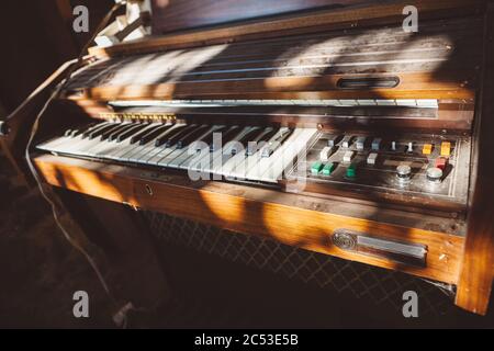 Alte staubige verlassene Vintage-Synthesizer in Chiaroscuro - mit Spiel des Lichts und Schatten auf ihm Stockfoto