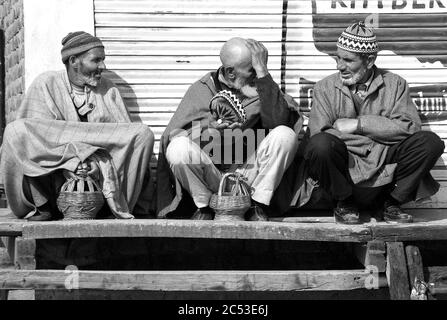 Kaschmir, Indien. Männer in Pherans, der traditionelle kashmiri Mantel, warm halten mit Feuer-Töpfe, die häufig als lokale Heizsysteme verwendet werden. März 14, 20 Stockfoto