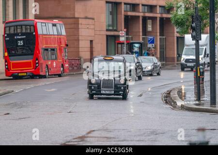 LONDON, ENGLAND - 10. JUNI 2020: Traditionelles schwarzes Londoner Taxi an einem niesigen Tag in Holborn, London während der COVID-19 Pandemie 088 Stockfoto