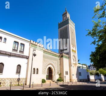 Eingang der Großen Moschee von Paris am Fuße des 33 Meter hohen Minaretts, mit dem Stern und der Halbmond über dem Eingang gegen blauen Himmel. Stockfoto