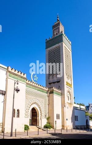 Eingang der Großen Moschee von Paris am Fuße des 33 Meter hohen Minaretts, mit dem Stern und der Halbmond über dem Eingang gegen blauen Himmel. Stockfoto