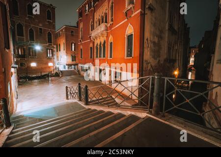 Gotisches Viertel mit alten roten Ziegelsteinmauern Häuser in der Nacht. Leere Gassen und Brückentreppen in Venedig, Italien. Stockfoto