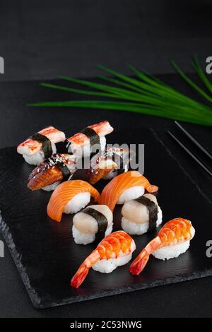 Nahaufnahme von Nigiri-Sushi mit frischen Garnelen, Lachs, Jakobsmuscheln, geräuchertem Aal Stockfoto