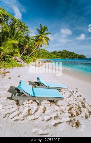 Mahe, Seychellen. Zwei Sonnenliegen am wunderschönen Anse intendance Strand. Blaues Meer, weißer Sand und Kokospalmen. Reisekreationskonzept. Stockfoto