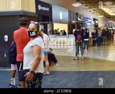 FRESNO, USA - Jun 08, 2020: Eine Frau wartet in einer langen Schlange zum Apple Store, um in der Fashion Fair Mall zu eröffnen, trägt ihre LOL Gesichtsmaske in Fre Stockfoto