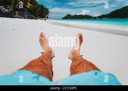 Männliche Beine Füße am tropischen Strand. Genießen Sie erholsamen Urlaub Urlaub pov Konzept. Stockfoto