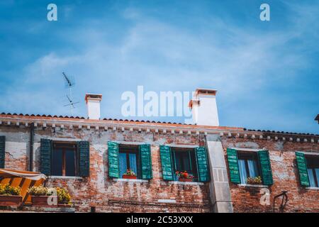 Italien. Venedig altes Haus mit Vintage-Fassade mit Holzfenstern auf der Straße. Stockfoto