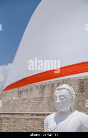 Buddha-Statue bei weißen Dagoba, Kuppeldach eines Tempels in Sri Lanka Stockfoto