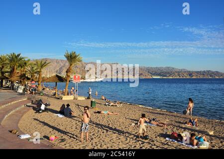 EILAT, ISRAEL - 31. MÄRZ 2015: Tourist Entspannung am öffentlichen Strand in Eilat bei Sonnenuntergang, berühmte internationale Resort - die südlichste Stadt Israels Stockfoto