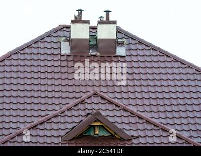 Eine rote Metalldachziegel mit einem Kamin oder Rauchfang Stockfoto