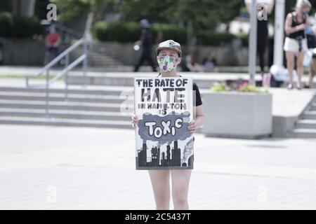 Eine Frau hält ein Protestplakat, während sich eine Menschenmenge im Rathaus von Hamilton versammelt, um friedlich zu protestieren, um Black Lives Matter zu unterstützen Stockfoto
