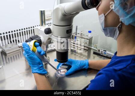 MOSKAU - 14. DEZEMBER 2016: Forscherin mit einem Mikroskop in einem Labor Stockfoto