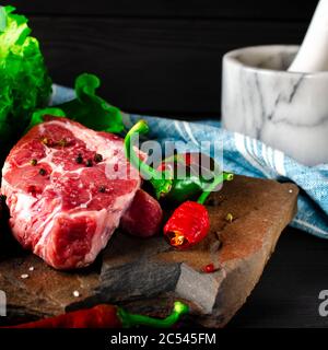 Rohes Fleisch Rindfleisch Marmorsteak mit Gewürzen und Gemüse Stockfoto