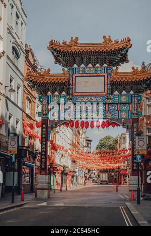 London, Großbritannien - 13. Juni 2020: Dekoratives Tor mit Qing-Dynastie-Designs auf leerer Straße in Chinatown, einem typisch belebten Viertel von London, das für seine Res Stockfoto