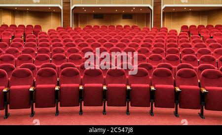 Panoramablick auf einen leeren Kinosaal. Reihen mit roten Sitzreihen. Panorama des modernen Kinos Interieur. Komfortsessel im Konferenzraum Stockfoto