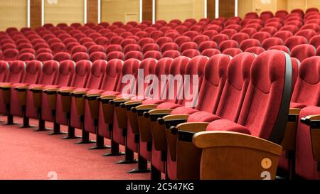 Reihen mit roten Sitzreihen. Panoramablick auf einen leeren Kinosaal. Komfortsessel im modernen Kino-Interieur. Stockfoto