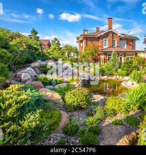 Region Moskau - 24. Aug 2019: Landschaftsgestaltung des Hausgartens. Wunderschöne Landschaft mit kleinem Teich. Landschaftlich gestalteter Platz mit Felsen im Sommer. Schönes Land Stockfoto