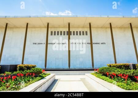 Vorderansicht des Kennedy Center in Washington, D.C. flankiert von zwei Blumenbeeten voller roter Tulpen an einem sonnigen Frühlingstag Stockfoto