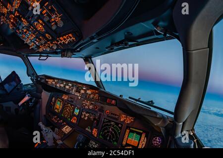 Flugzeug Cockpit Atmosphäre fliegen in Richtung der entgegenkommenden Nacht in der Dämmerung. Pilot Perspektive auf wunderschönen Sonnenuntergang aus dem Inneren des Flugdecks Stockfoto