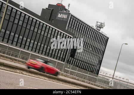 Ein Mini passiert heute die Mini Plant an der Oxford Ringstraße. Neun Fälle von Covid-19 wurden dort heute bestätigt. Erst kürzlich nahm das Werk die Produktion wieder auf, nachdem die Sperrung gelockert wurde. Stockfoto