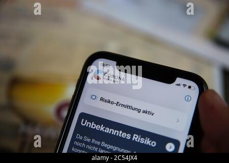 Viersen, Deutschland - Juni 30. 2020: Nahaufnahme des Handybildschirms mit männlicher Hand mit original deutscher Regierung covid-19 Warnungs-App (Fokus auf wo Stockfoto