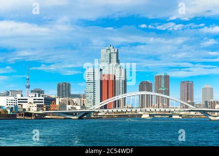 tokio, japan - märz 15 2020: Bogenbrücke von Tsukiji Ohashi am Sumida Fluss, durchzogen von der Kanni Straße mit den Wolkenkratzern des Tsukiji Distrikts A Stockfoto