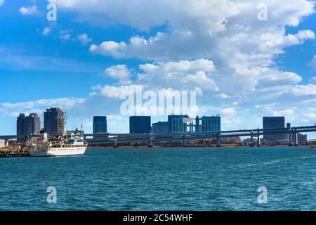 tokio, japan - april 04 2020: Boot vor der zweischichtigen Regenbogenbrücke mit der Bucht von Odaiba und dem Einkaufszentrum Bui an der Küste der Bucht von Tokyo Stockfoto