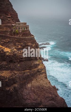 Santo Antao. Kap Verde. Atemberaubende Landschaft des Küstenweges. Steile schwarze Klippen dehnten sich nach vorne aus, riesige Wellen krachten gegen steiles Felsufer. Stockfoto