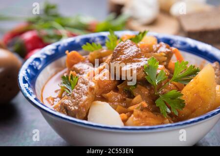 Ungarischer Gulasch, Schweinefleisch oder Rind-Eintopf in runder Schüssel serviert Stockfoto