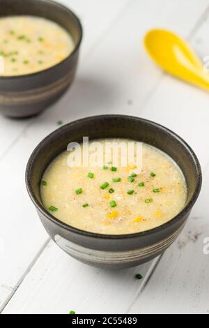 Maissuppe mit Ei und Huhn. Ein kantonesisches Gericht, das in chinesischen Restaurants oft als Vorspeise serviert wird. Die Schüssel mit Suppe ist auf weißem Hintergrund. E Stockfoto