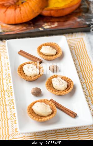 Süße Buttertorte. Mini-Zuckerpasteten (oder Buttertörtchen) mit einer knackigen Backkruste, einer süßen Füllung und Kürbis-Gewürz-Schlagsahne darauf. Ein Schmunst Stockfoto