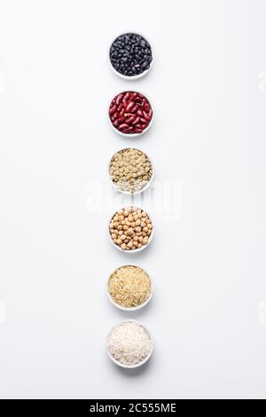 Verschiedene Hülsenfrüchte und Körner Draufsicht. Schalen von Grundnahrungsmitteln wie Kichererbsen, rote Kidney Bohnen, grüne Linsen, schwarze Schildkröten Bohnen, Jasmin ric Stockfoto