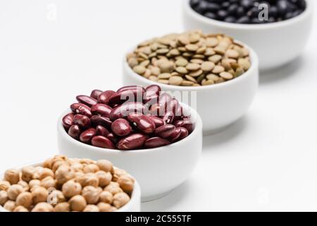 Rote Bohnen und verschwommene Hülsenfrüchte. 4 Sorten von Hülsenfrüchten (trockene essbare Samen von Pflanzen), der Fokus liegt auf den roten Kidney-Bohnen, während die anderen Hülsenfrüchte Stockfoto