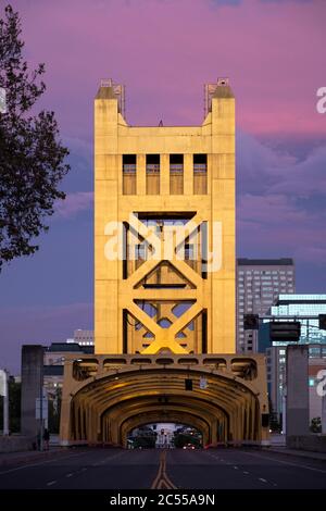 Der Himmel bei rosa Sonnenuntergang hinter der goldenen Tower Bridge über dem Sacramento River, der in die Innenstadt führt Stockfoto